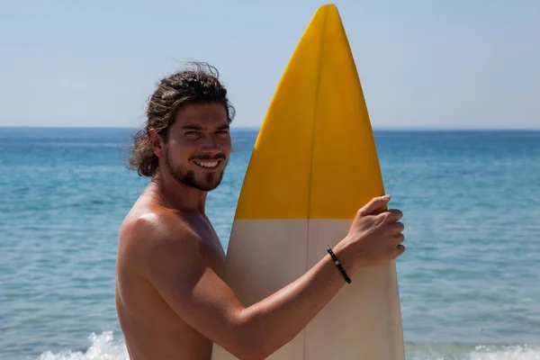 Серфер с доской для серфинга, стоящий на пляже — стоковое фото