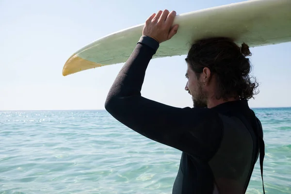 Surfer w kombinezon przewozu desek surfingowych — Zdjęcie stockowe