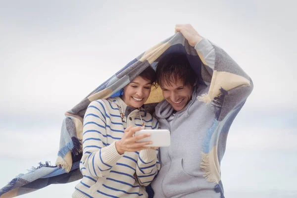 Couple using phone during winter — Stock Photo, Image