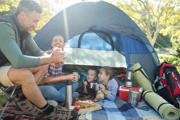 外テントをスナックをしながら家族の相互作用 — ストック写真