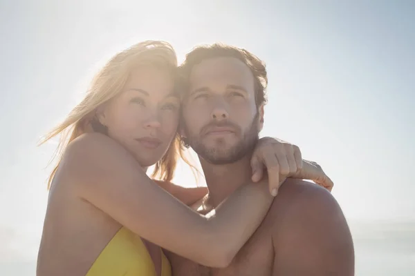 Thoughtful couple embracing at beach — Stock Photo, Image