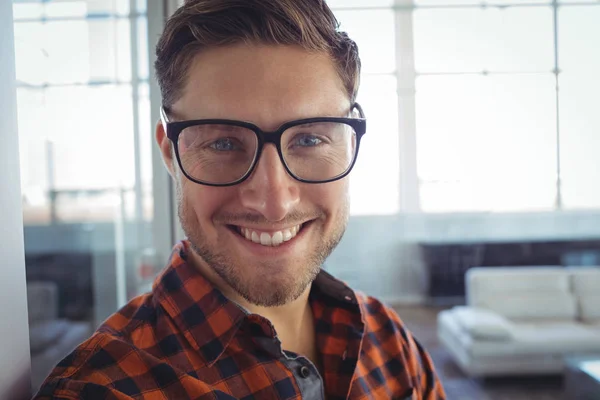 Hombre de negocios sonriente de pie en el cargo — Foto de Stock