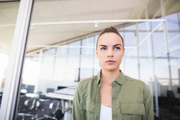 Pensamiento mujer de negocios contra pared de vidrio — Foto de Stock