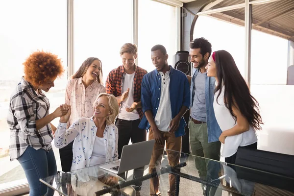 Affärskvinna med medarbetare på kreativa kontor — Stockfoto