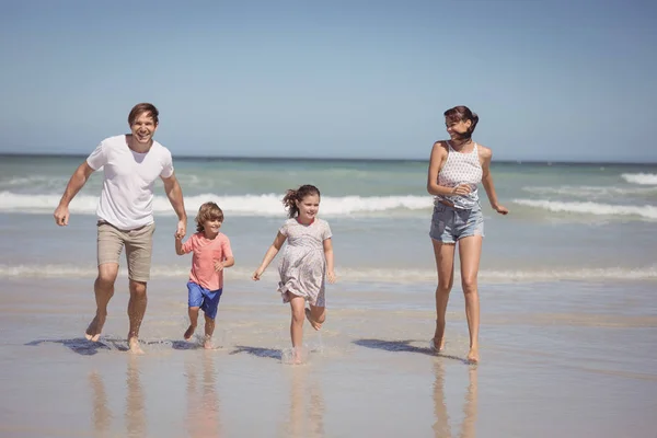 Семья бежит на берег на пляже — стоковое фото