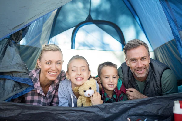 Lachende familie liggen in de tent — Stockfoto