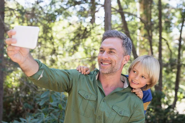 Far och son tar selfie i skogen — Stockfoto