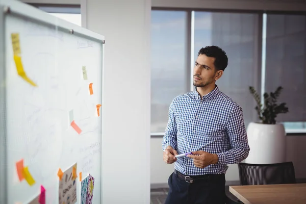 Tankeväckande verkställande tittar på whiteboard — Stockfoto