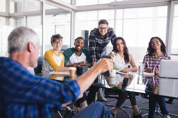 Equipo mirando el teléfono en poder del hombre de negocios — Foto de Stock