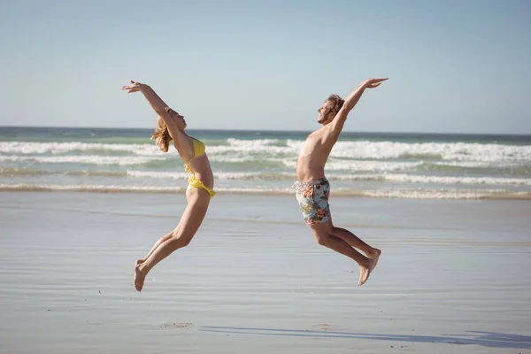 Пара прыжки на берег в — стоковое фото