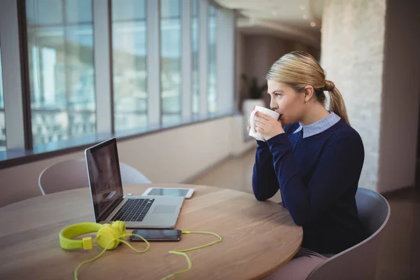 Female executive having cup of coffee — Stock Photo, Image