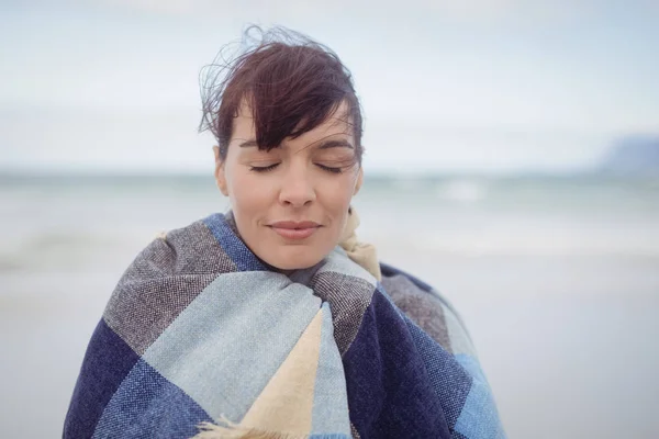 Femme avec les yeux fermés enveloppé dans une couverture — Photo