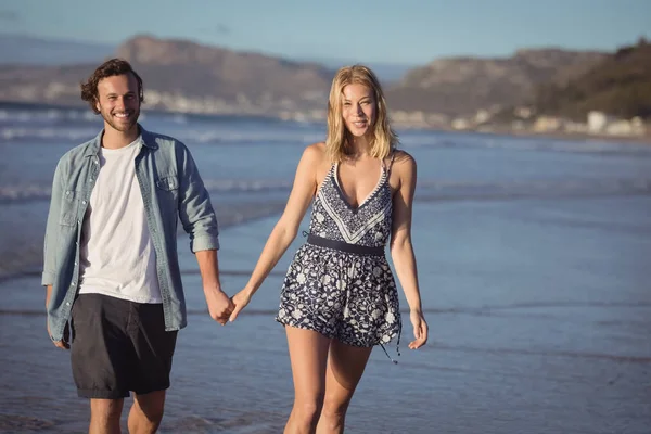 Happy couple holding hands on shore — Stock Photo, Image