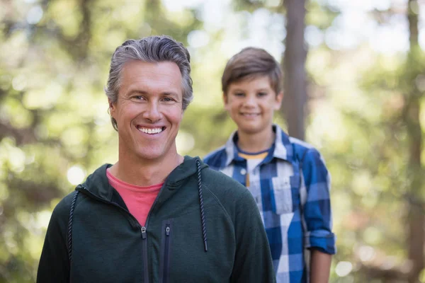 Vader en zoon wandelen in het bos — Stockfoto