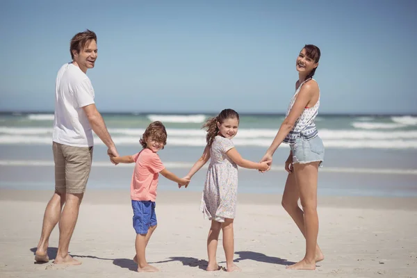 Familie hält Händchen am Strand — Stockfoto