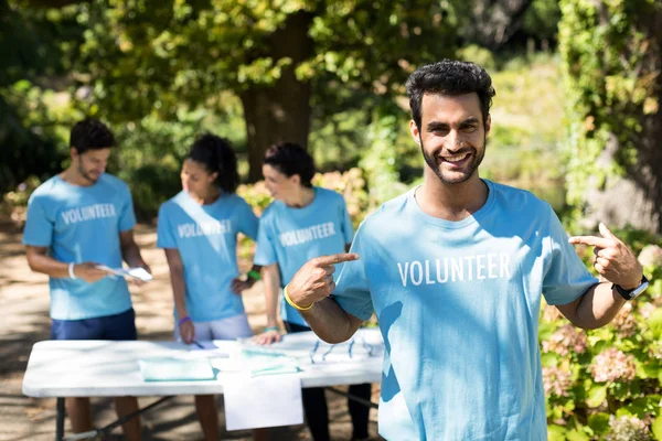 Freiwilliger zeigt auf sein T-Shirt — Stockfoto