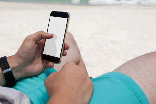 Člověk používající mobilní telefon na pláži — Stock fotografie
