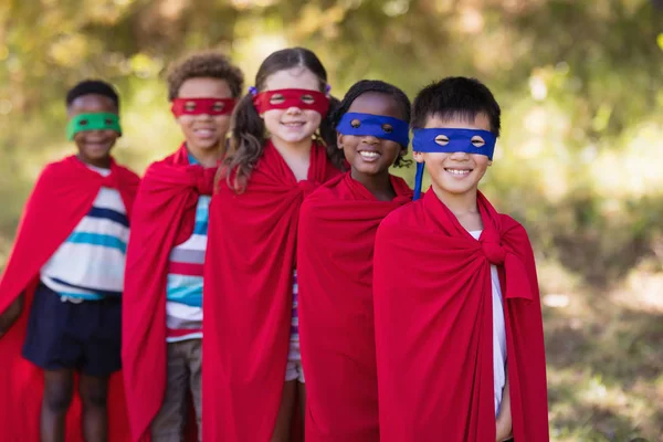 Amigos en trajes de superhéroes de pie en el camping — Foto de Stock