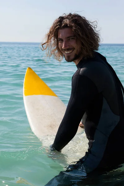 Surf seduto sulla tavola da surf in riva al mare — Foto Stock