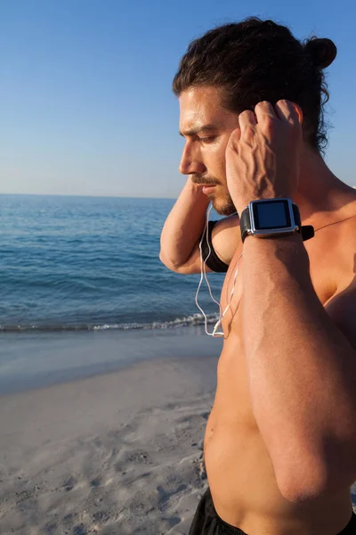 Muskulöser Mann hört Musik über Kopfhörer — Stockfoto