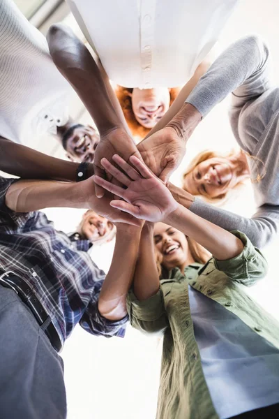 Lachende business mensen stapelen handen — Stockfoto