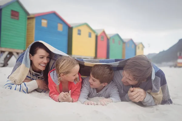 Счастливая семья лежит на песке — стоковое фото