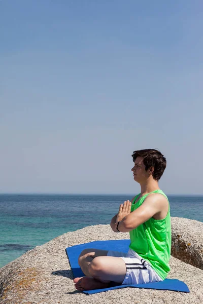 Człowiek, wykonując jogi na skale — Zdjęcie stockowe