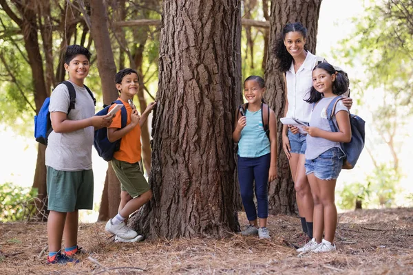 Studenti e insegnante in piedi vicino all'albero — Foto Stock