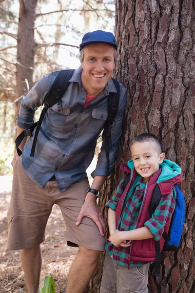 Far och son lutar på trädstam — Stockfoto