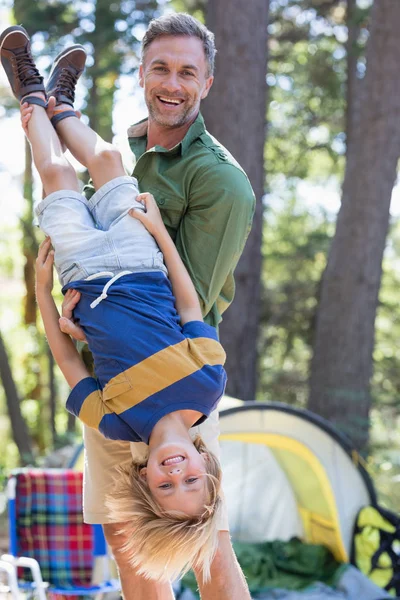 Padre tenendo figlio a testa in giù al campeggio — Foto Stock