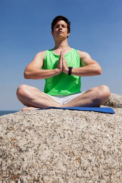 Uomo che esegue yoga su roccia — Foto Stock