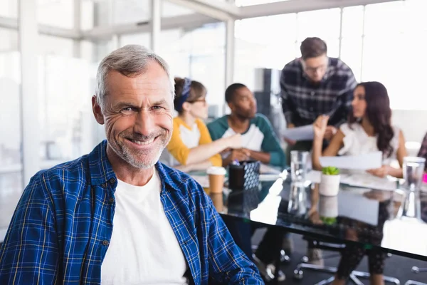 Businessman with team working in background — Stock Photo, Image