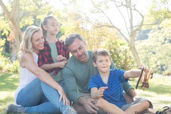 Familjen tittar på pojke leker med leksak flygplan — Stockfoto