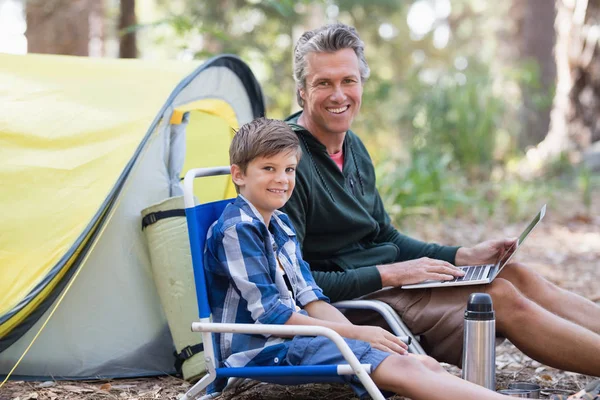 Отец и сын с ноутбуком в лесу — стоковое фото