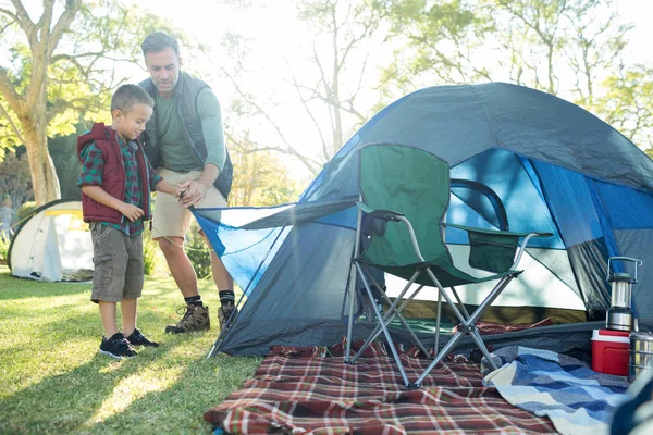 Отец и сын устанавливают палатку в кемпинге — стоковое фото