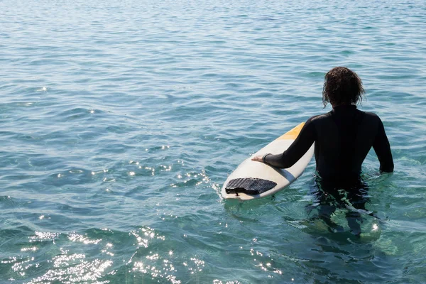 Surfer z deski surfingowej stojący w morze — Zdjęcie stockowe