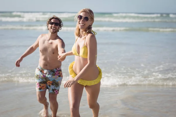 Couple running on shore at beach` — Stok fotoğraf