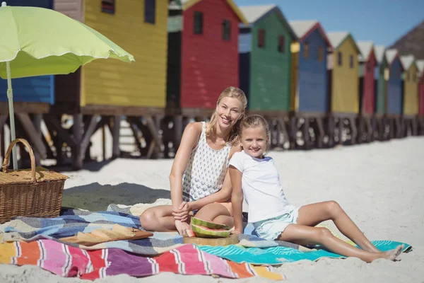 Женщина с дочерью сидят на пляже — стоковое фото