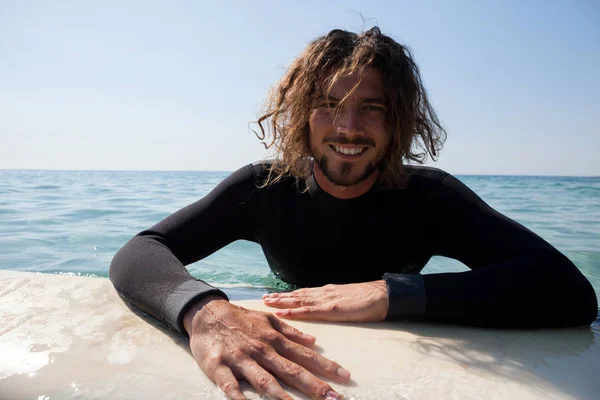 Surfer lutande på surfbräda i havet — Stockfoto