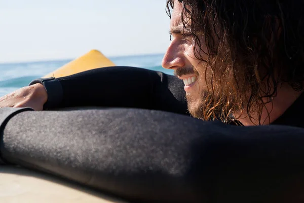 Surfista apoyado en tabla de surf en el mar —  Fotos de Stock