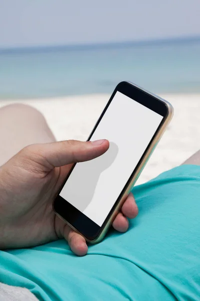 Člověk používající mobilní telefon na pláži — Stock fotografie