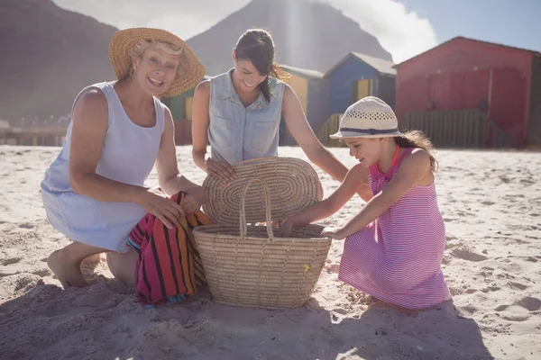 Mehrgenerationenfamilie mit Picknickkorb auf Sand — Stockfoto