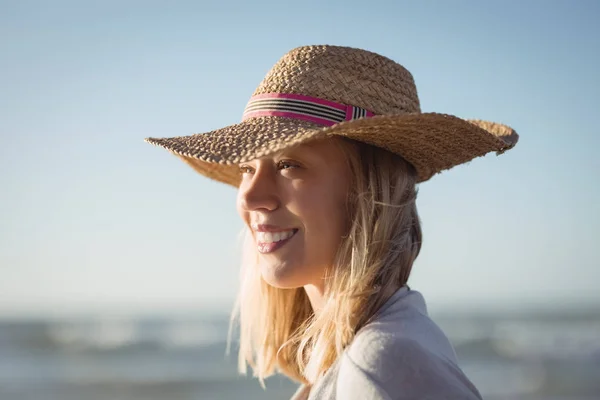 Frau schaut weg, während sie Sonnenhut trägt — Stockfoto