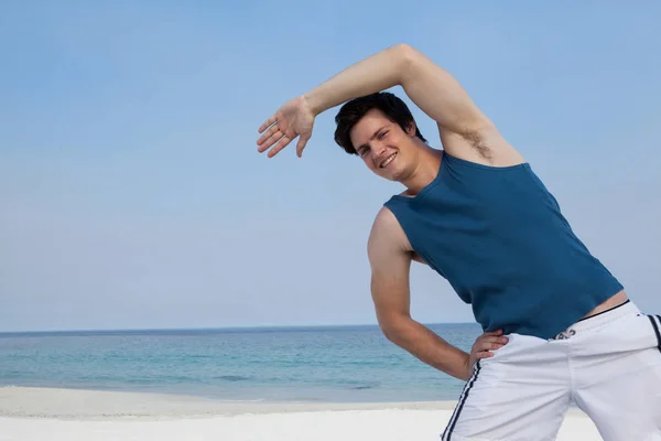 Чоловік робить розігрів на пляжі — стокове фото