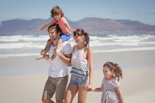 Счастливая семья, гуляющая на пляже — стоковое фото