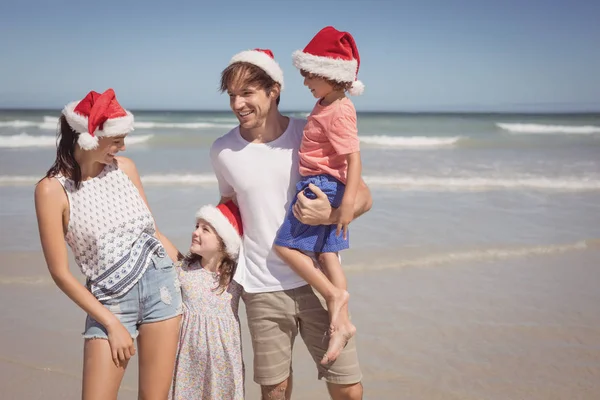 Famille portant le chapeau de Père Noël à la plage — Photo