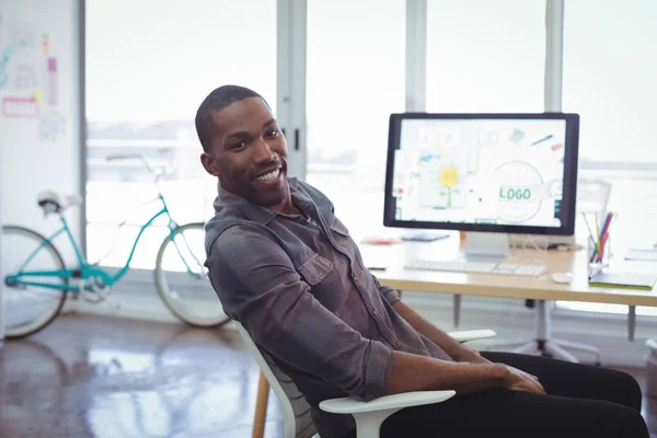 Businessman sitting in brightly lit office — Stock Photo, Image