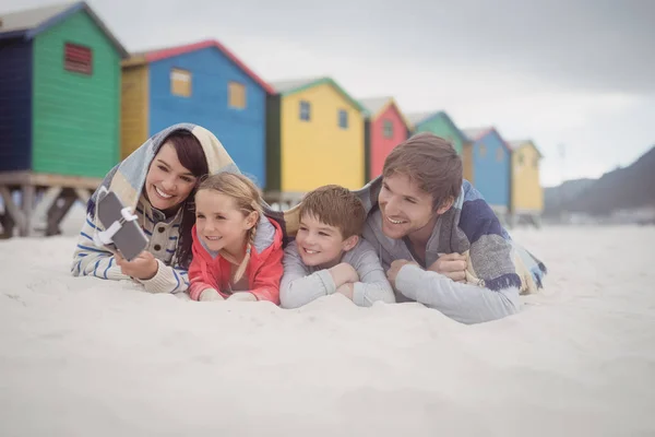 Familia tomando selfie mientras está acostado en la arena — Foto de Stock