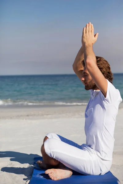 Man utför yoga på stranden — Stockfoto