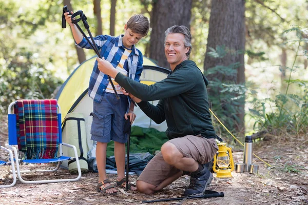 Padre dando palo da trekking a figlio nella foresta — Foto Stock